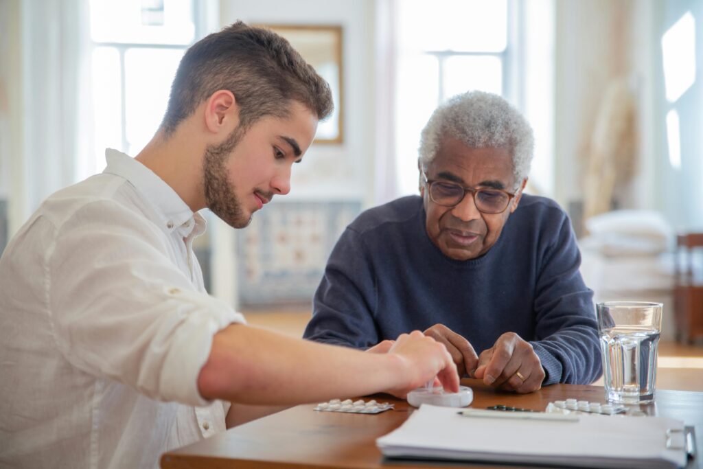 Senior care attendant helping a senior with medication